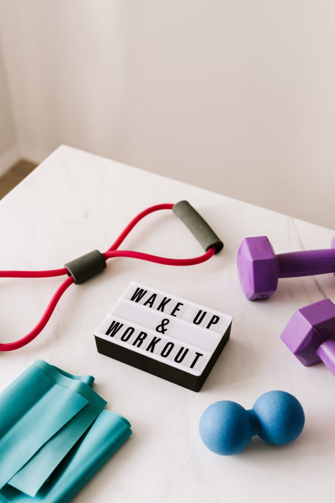 A few colourfull workout items arranged around a sign that says: Wake up and Workout".